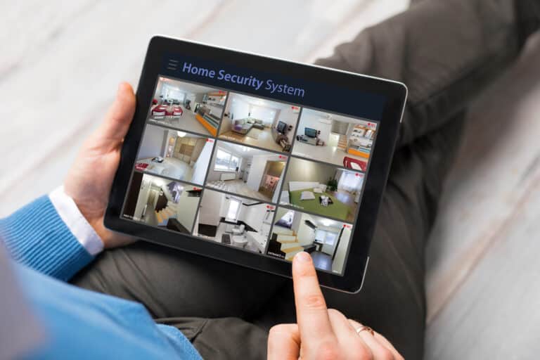 Man,Looking,At,Home,Security,Cameras,On,Tablet,Computer